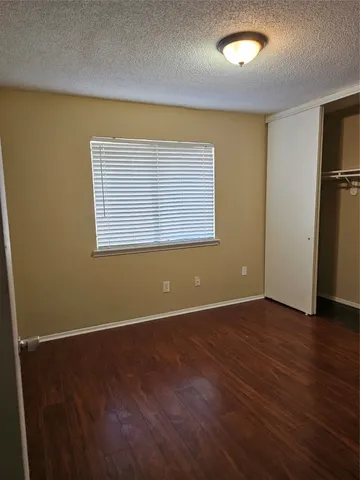 an empty room with wooden floor and a window