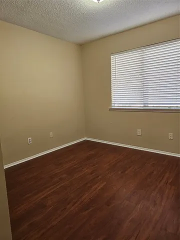 a view of a room with wooden floor and a window