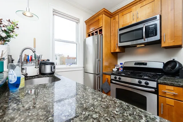 a kitchen with stainless steel appliances granite countertop a stove a sink and a microwave