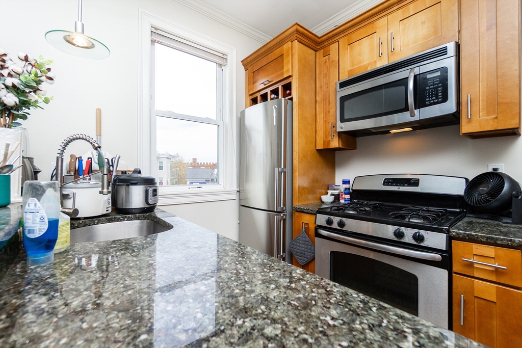 55 Kelly Road, Unit 3 Cambridge, MA 02139 - Photo 7 of 10 a kitchen with stainless steel appliances granite countertop a stove a sink and a microwave