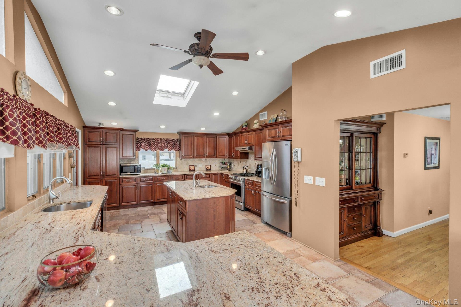 1044 Commack Road Dix Hills, NY 11746 - Photo 16 of 29 Kitchen with recessed lighting, a skylight, light stone countertops, stainless steel appliances, and stone tile flooring