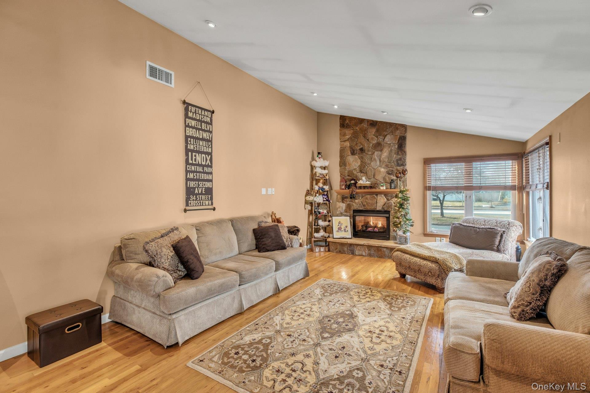 1044 Commack Road Dix Hills, NY 11746 - Photo 9 of 29 Living area with vaulted ceiling, a fireplace, wood finished floors, and recessed lighting