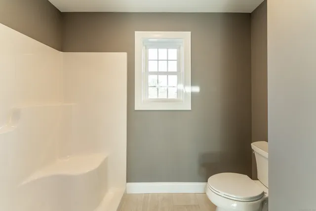 a white toilet sitting next to a bath tub