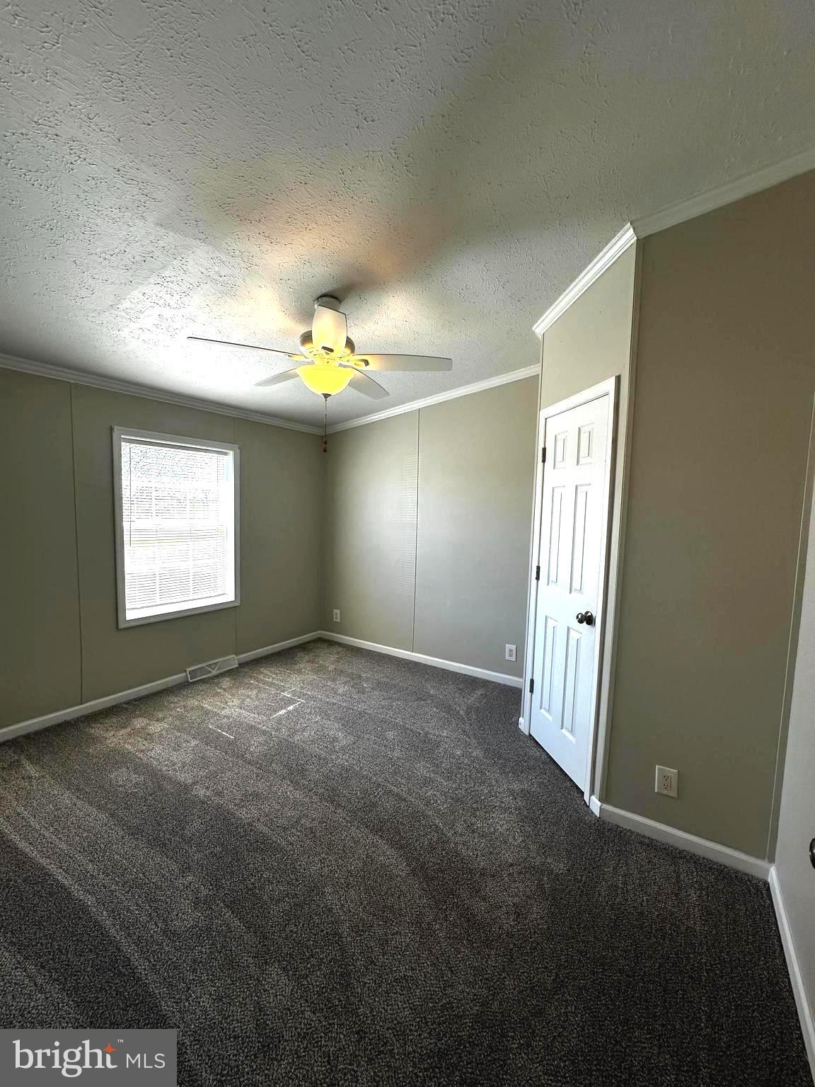 11433 Trussum Pond Road Laurel, DE 19956 - Photo 22 of 27 an empty room with windows and chandelier fan