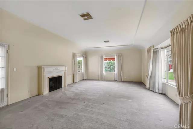a view of a dining room with furniture a chandelier and large windows