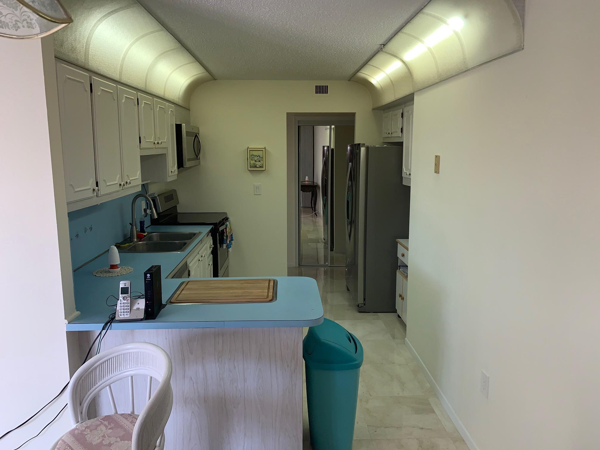 4200 North Ocean Drive, Unit 103 Riviera Beach, FL 33404 - Photo 11 of 16 a hallway with a couch and chandelier