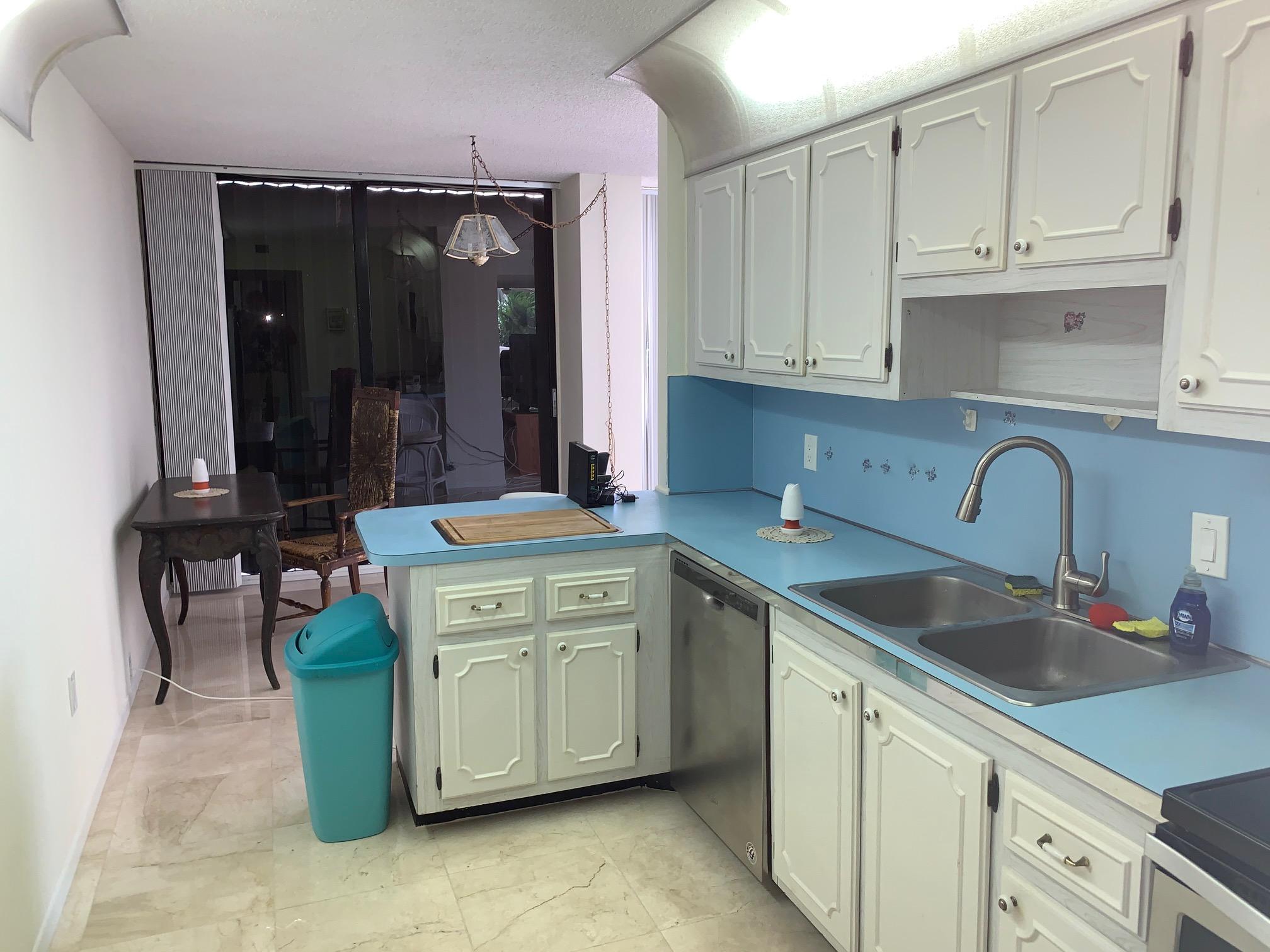 4200 North Ocean Drive, Unit 103 Riviera Beach, FL 33404 - Photo 10 of 16 a kitchen with a sink and cabinets