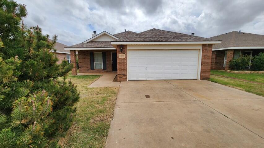 6535 93rd Street Lubbock, TX 79424 - Photo 1 of 13 a front view of a house with a garden and yard
