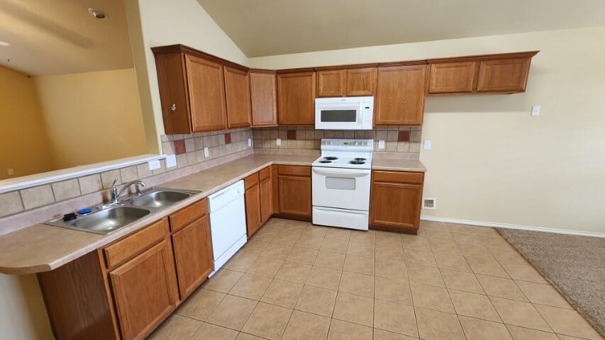 6535 93rd Street Lubbock, TX 79424 - Photo 4 of 13 a kitchen with stainless steel appliances granite countertop a sink stove and refrigerator