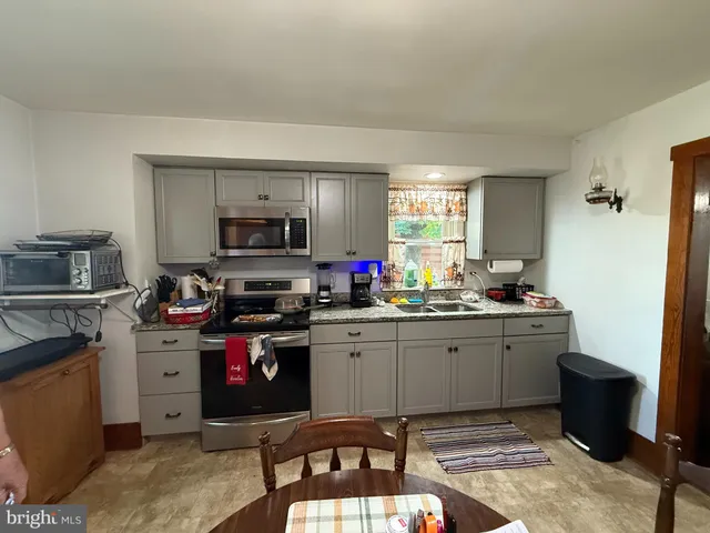 a kitchen with granite countertop a sink cabinets and stainless steel appliances