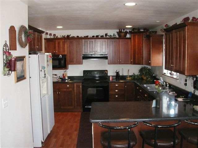 1318 West Spruce Court Rifle, CO 81650 - Photo 3 of 4 a kitchen with refrigerator and cabinets