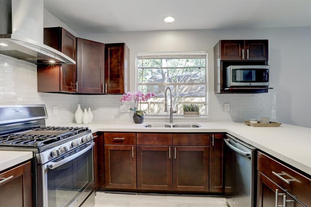 a kitchen with stainless steel appliances a sink stove and microwave