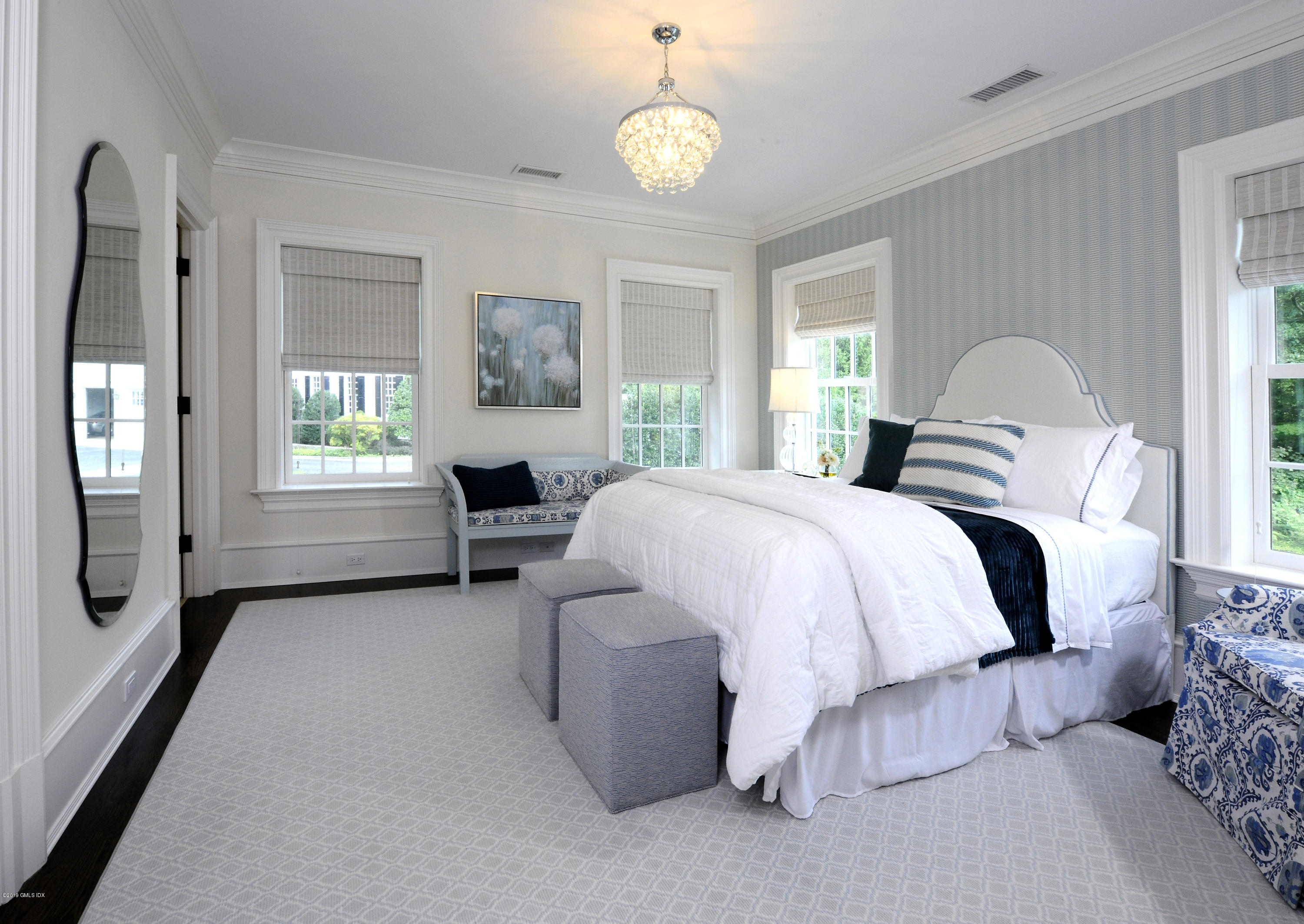 22 Cornelia Drive Greenwich, CT 06830 - Photo 17 of 34 a spacious bedroom with a bed and a chandelier