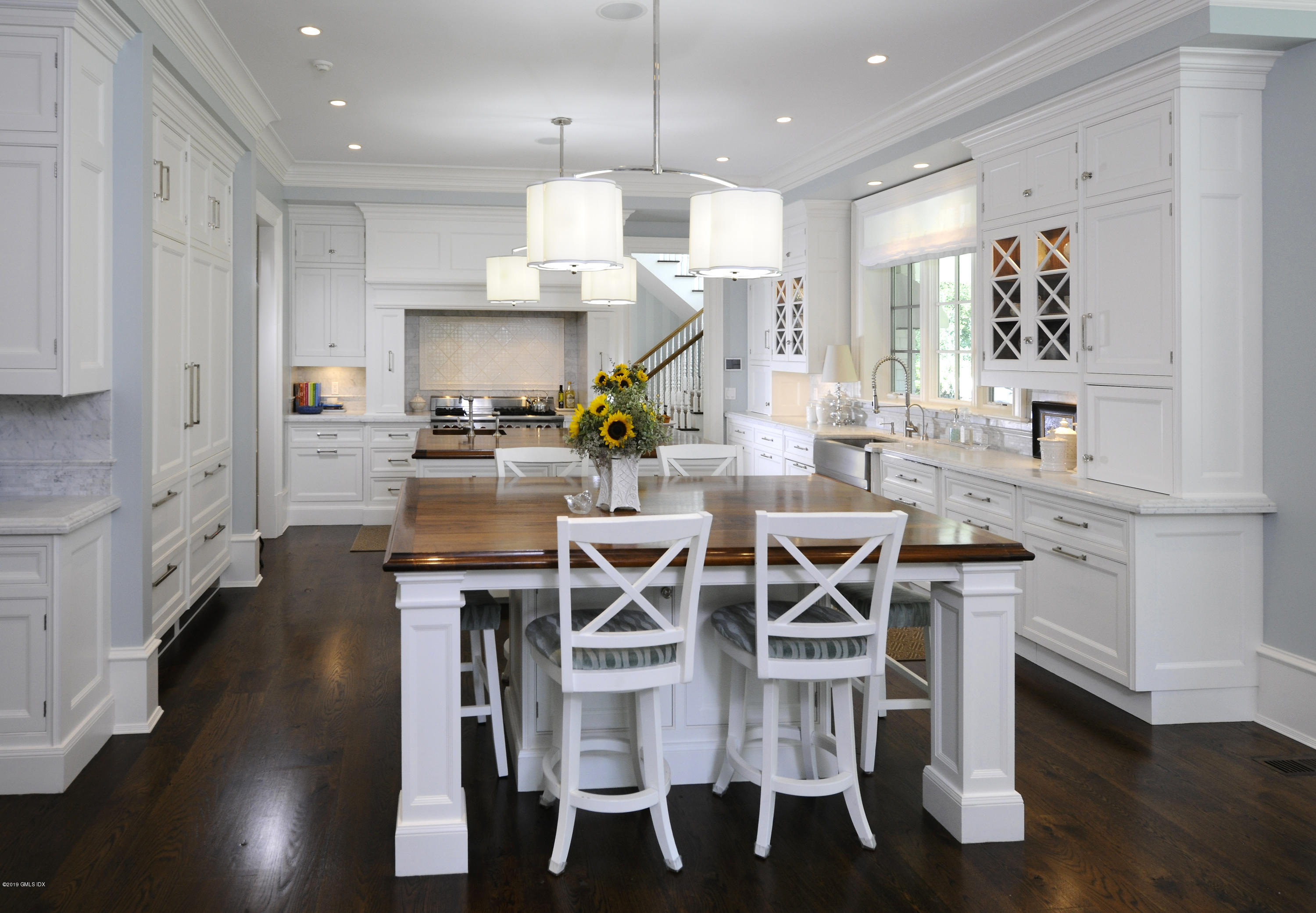 22 Cornelia Drive Greenwich, CT 06830 - Photo 8 of 34 a kitchen with stainless steel appliances kitchen island granite countertop a table chairs sink and cabinets