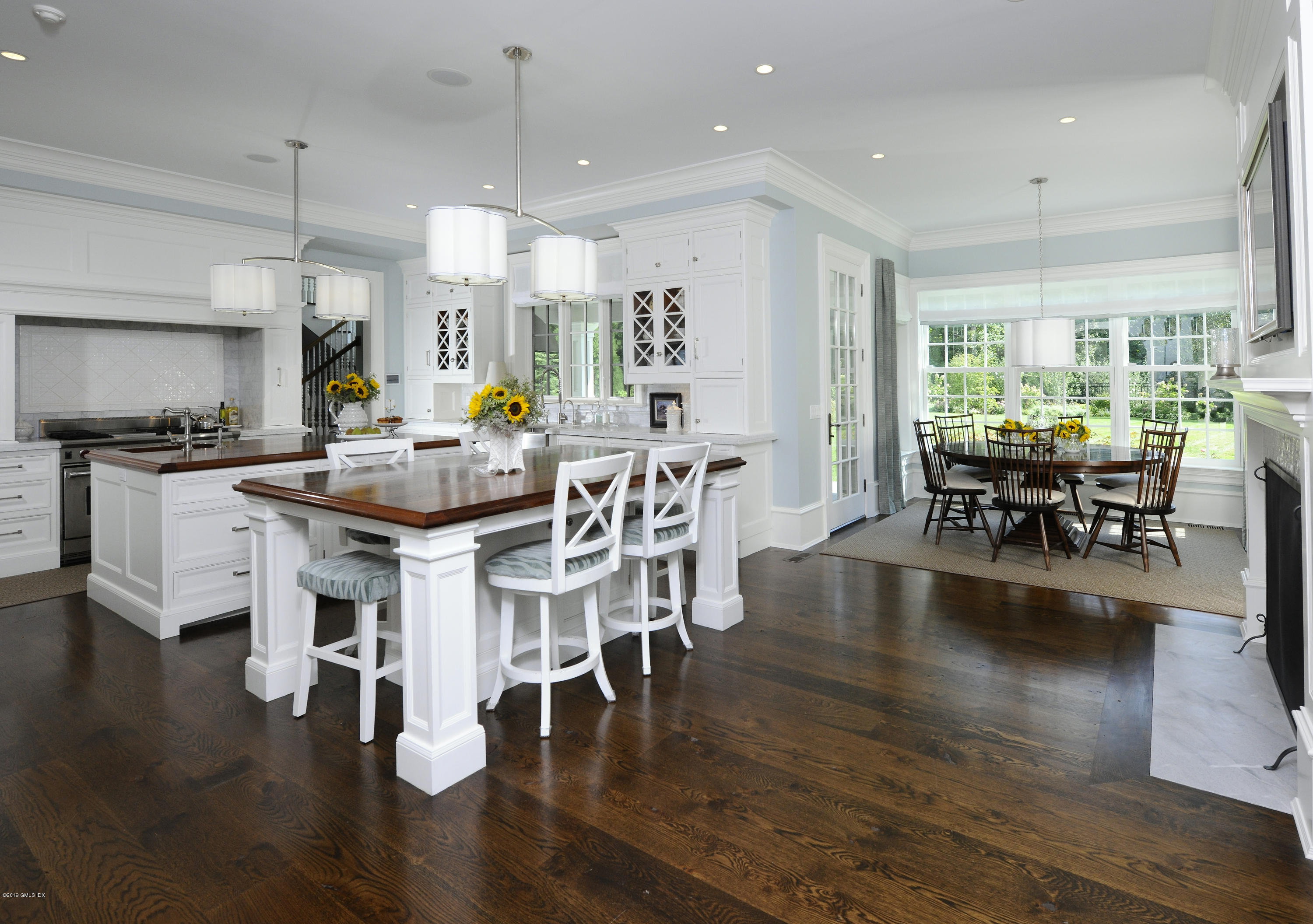 22 Cornelia Drive Greenwich, CT 06830 - Photo 9 of 34 a dining room with wooden floor a chandelier a glass table and chairs