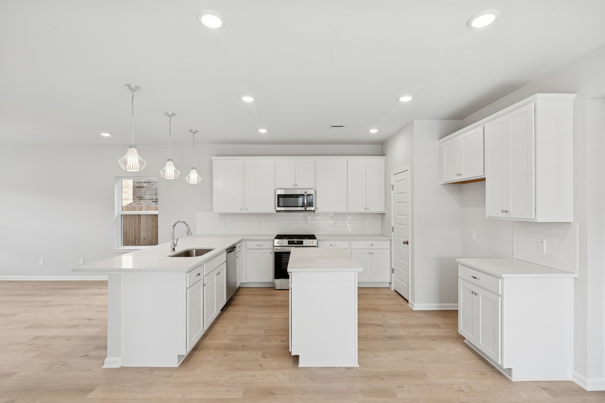9761 Enclave Ridge Road Willis, TX 77318 - Photo 6 of 28 a large kitchen with stainless steel appliances kitchen island a large counter top and a stove top oven