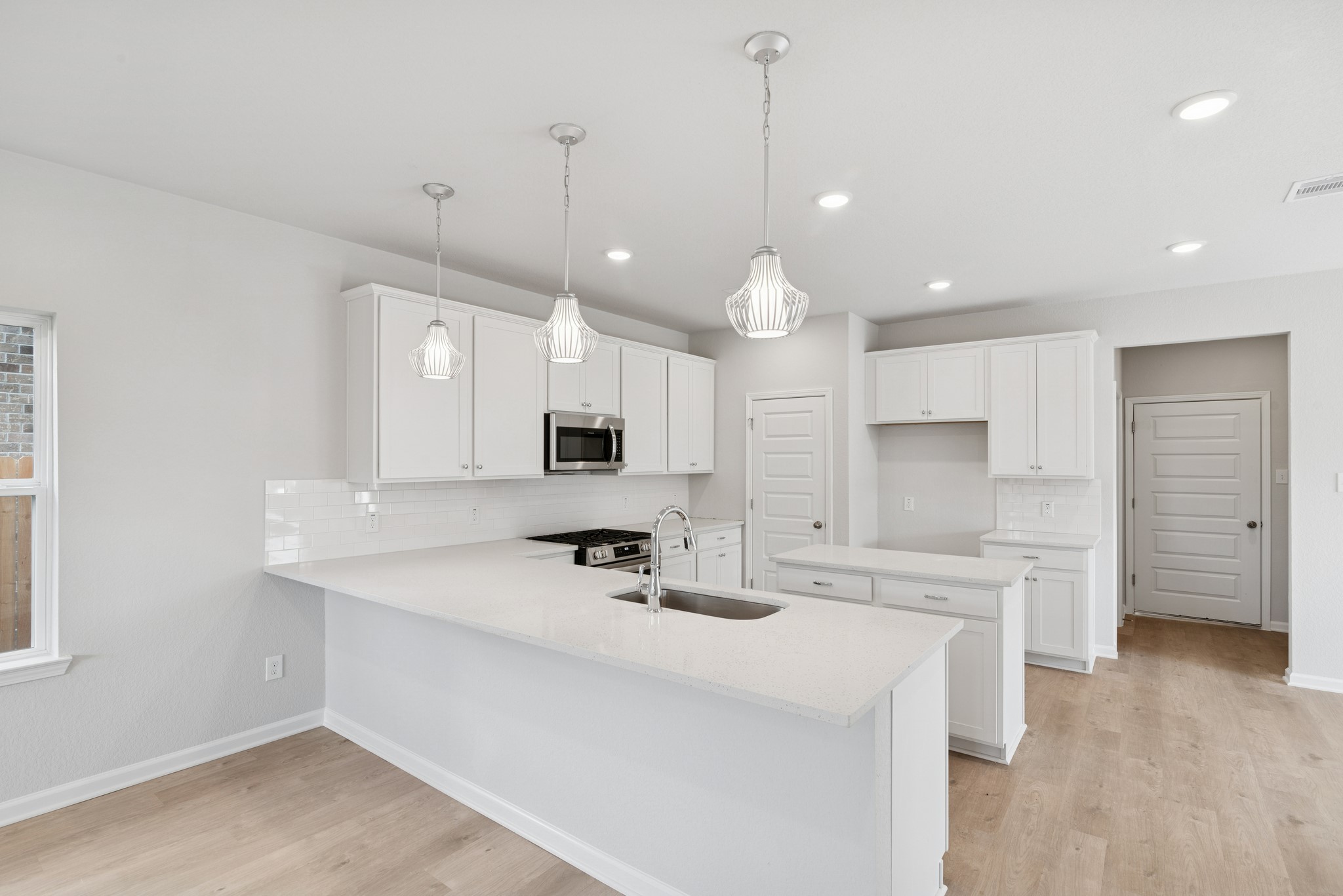 9761 Enclave Ridge Road Willis, TX 77318 - Photo 7 of 28 a kitchen with kitchen island a sink stainless steel appliances and white cabinets