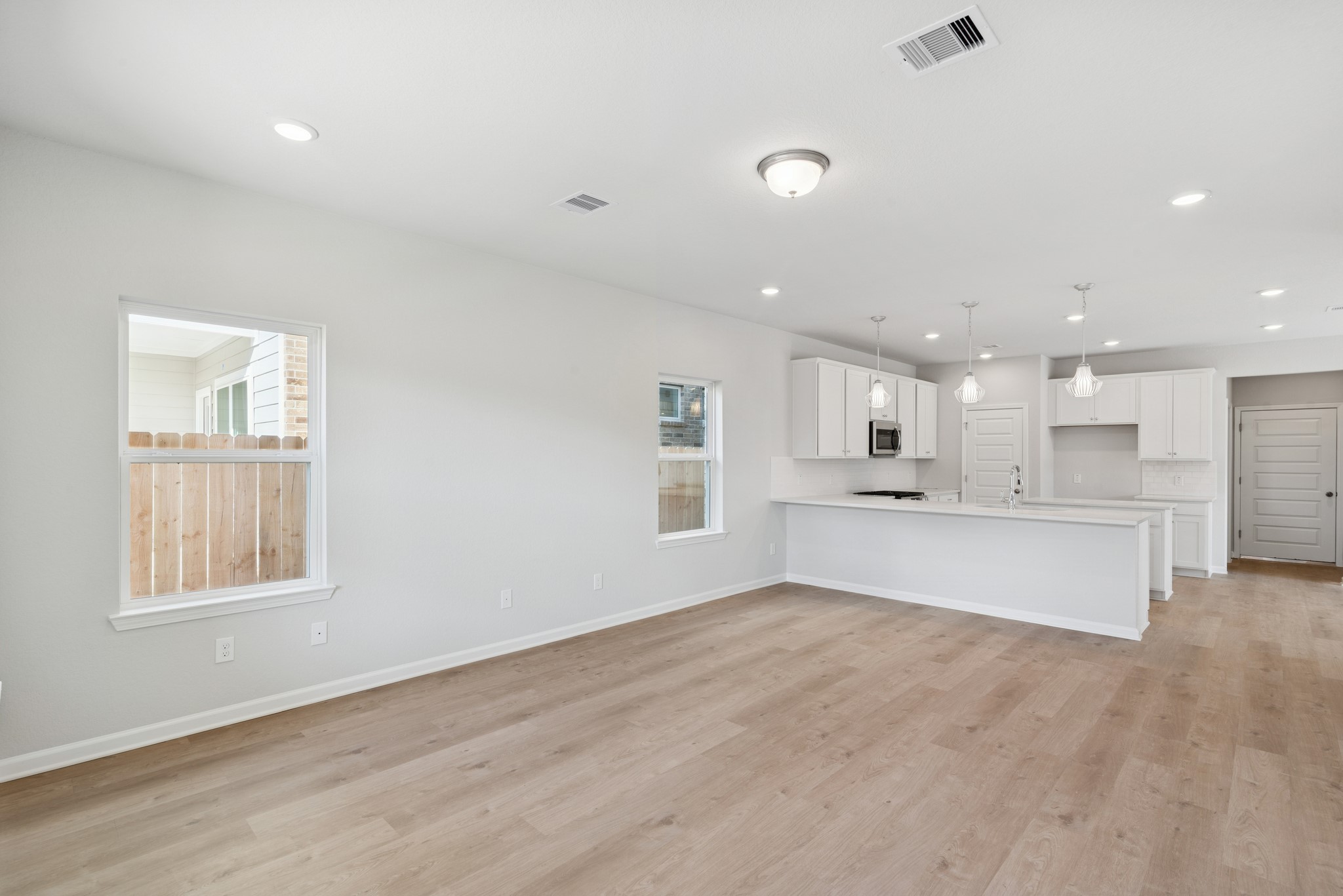 9761 Enclave Ridge Road Willis, TX 77318 - Photo 9 of 28 a large kitchen with white cabinets and wooden floor