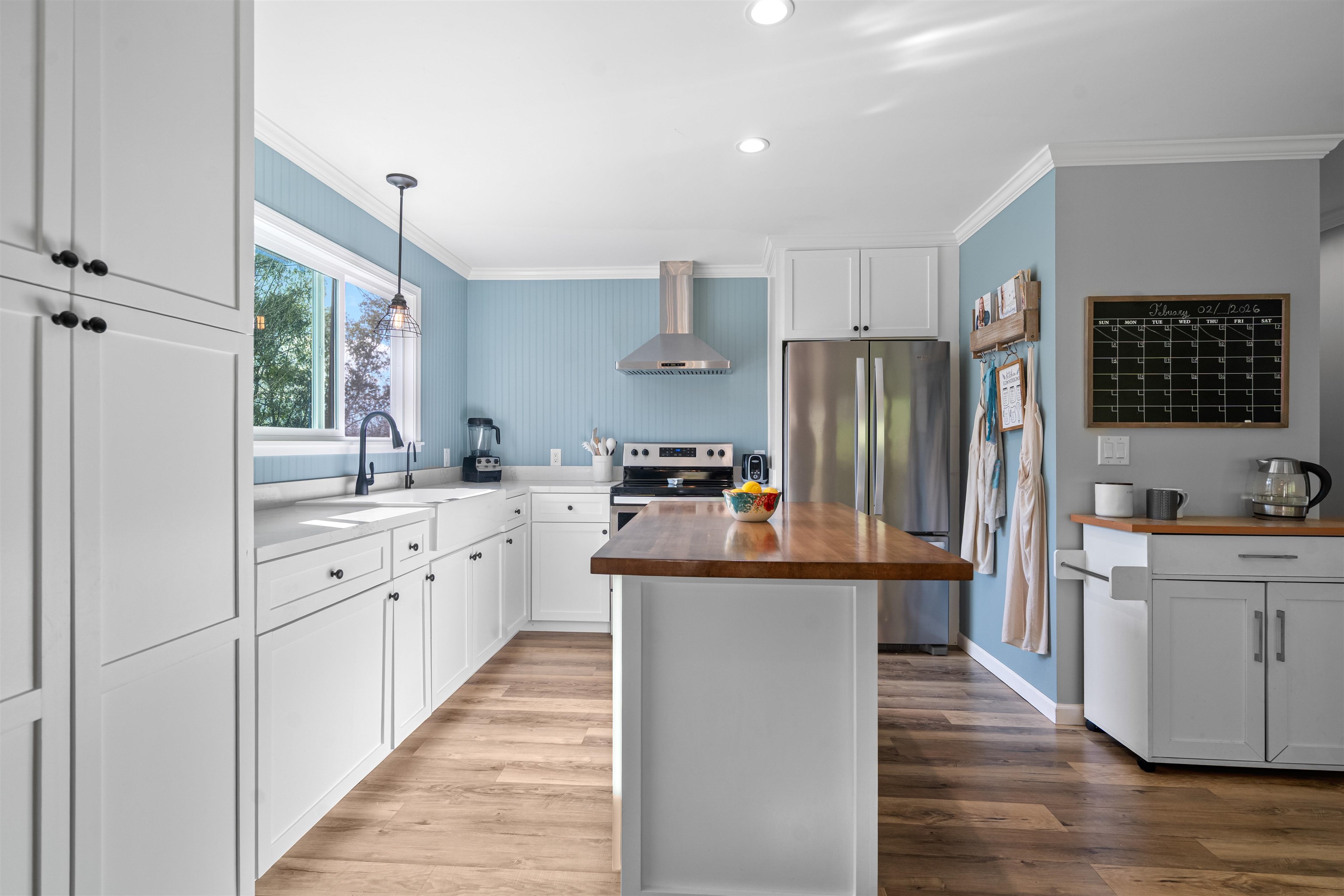 3281 Dunn Road Valley Springs, CA 95252 - Photo 14 of 59 Kitchen featuring white cabinetry, stainless steel appliances, a kitchen island, ornamental molding, and light wood finished floors