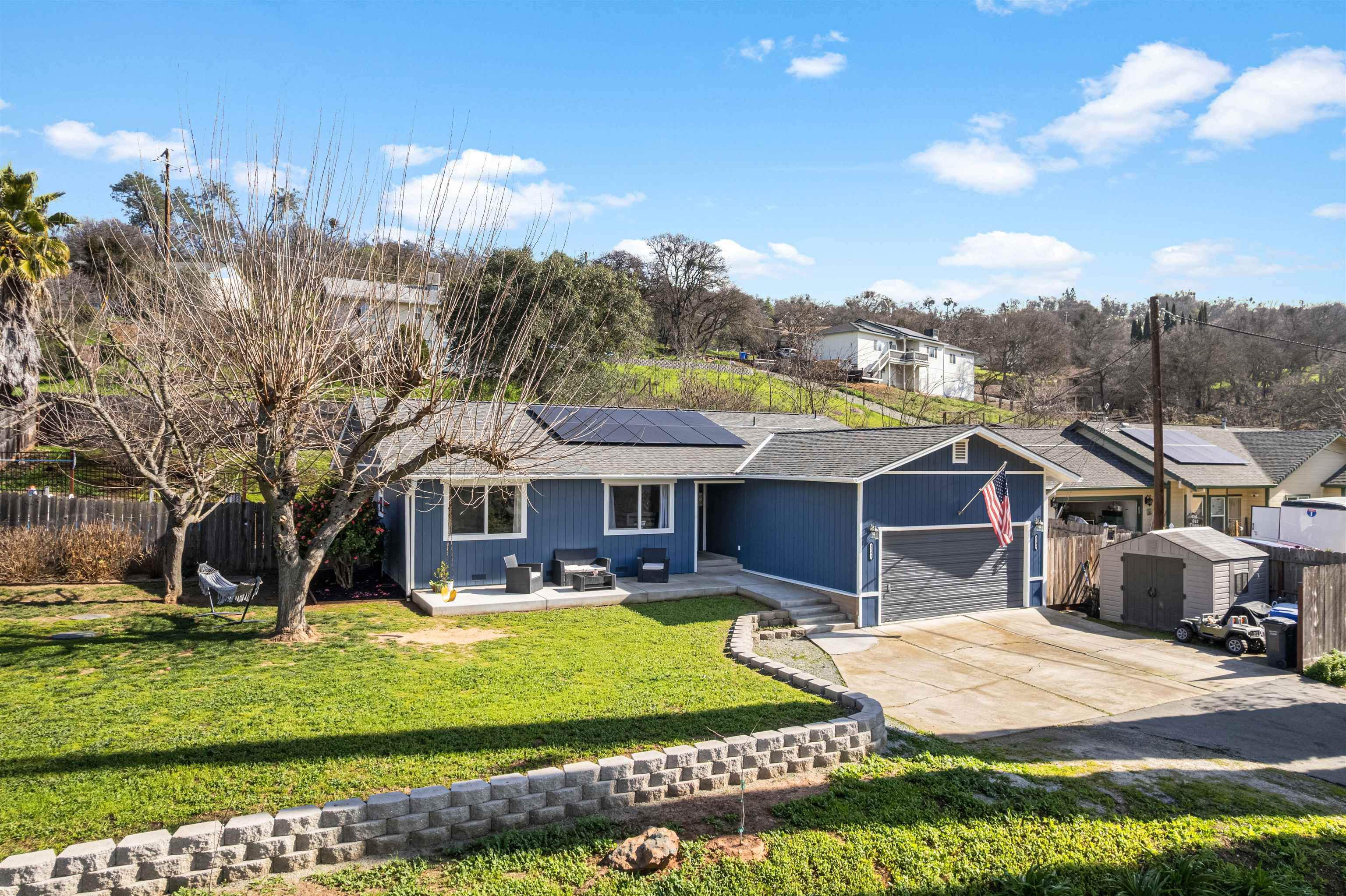 3281 Dunn Road Valley Springs, CA 95252 - Photo 3 of 59 Ranch-style house featuring roof mounted solar panels, driveway, an outdoor lounge area, a patio area, and a shingled roof