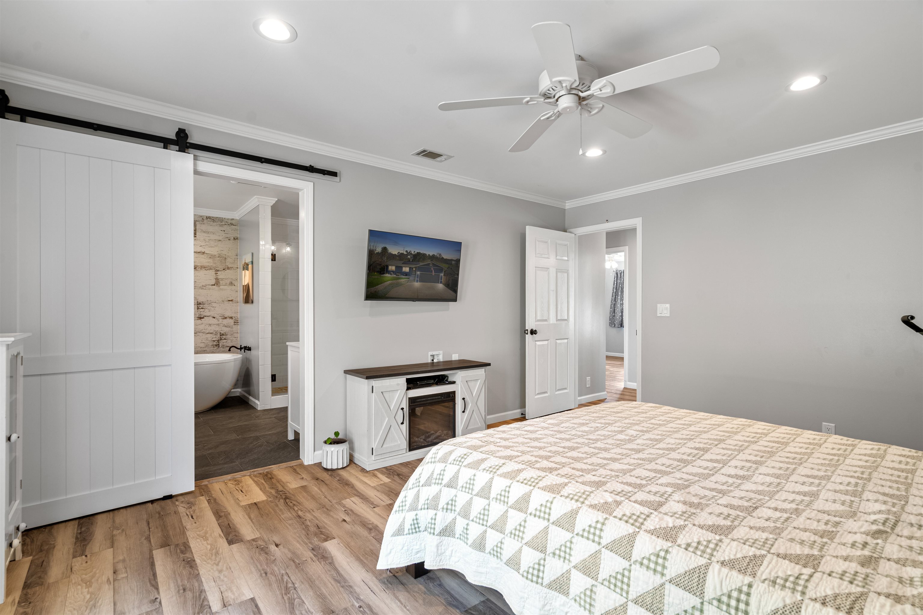 3281 Dunn Road Valley Springs, CA 95252 - Photo 31 of 59 Bedroom with a barn door, ornamental molding, light wood-style flooring, a ceiling fan, and recessed lighting
