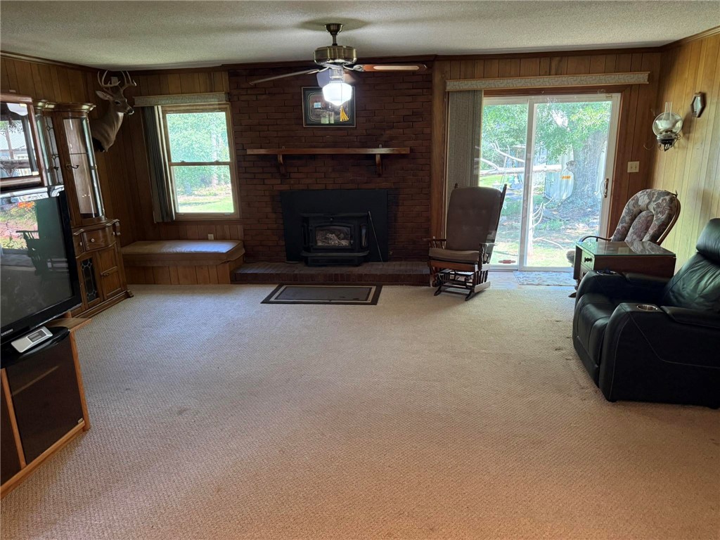 4027 Belhaven Road Belton, SC 29627 - Photo 7 of 24 Warm wood paneling and a brick fireplace create an inviting atmosphere in this generous living space.