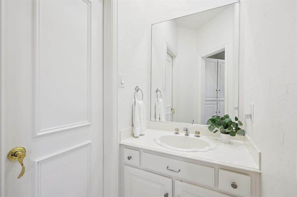 6065 Dilbeck Lane Dallas, TX 75240 - Photo 25 of 40 a bathroom with a sink and a mirror