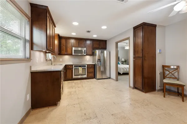 a kitchen with stainless steel appliances granite countertop a refrigerator and a stove top oven