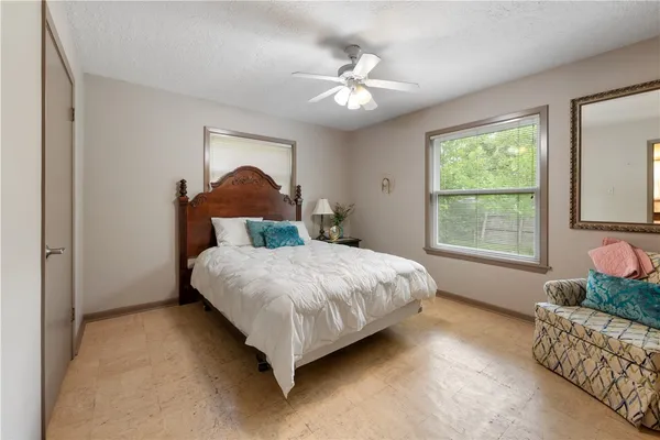 a bedroom with a bed chandelier and window