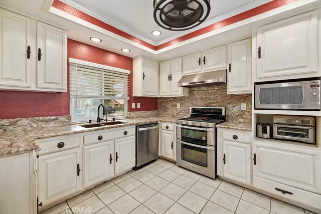 a kitchen with granite countertop cabinets stainless steel appliances and a sink