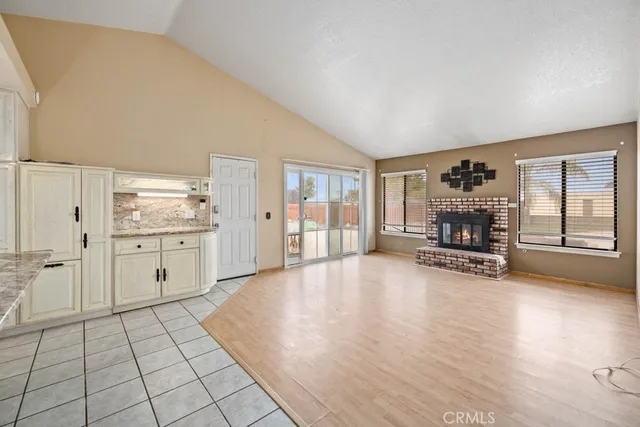 a view of empty room with wooden floor and fireplace