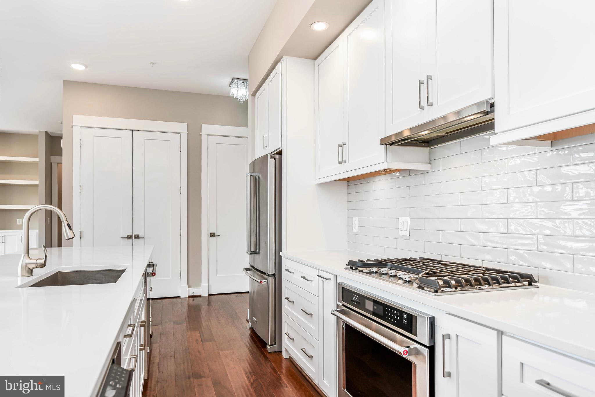2 Stationmaster Street Southeast, Unit 302 Leesburg, VA 20175 - Photo 11 of 57 a kitchen with stainless steel appliances a stove a sink and a refrigerator