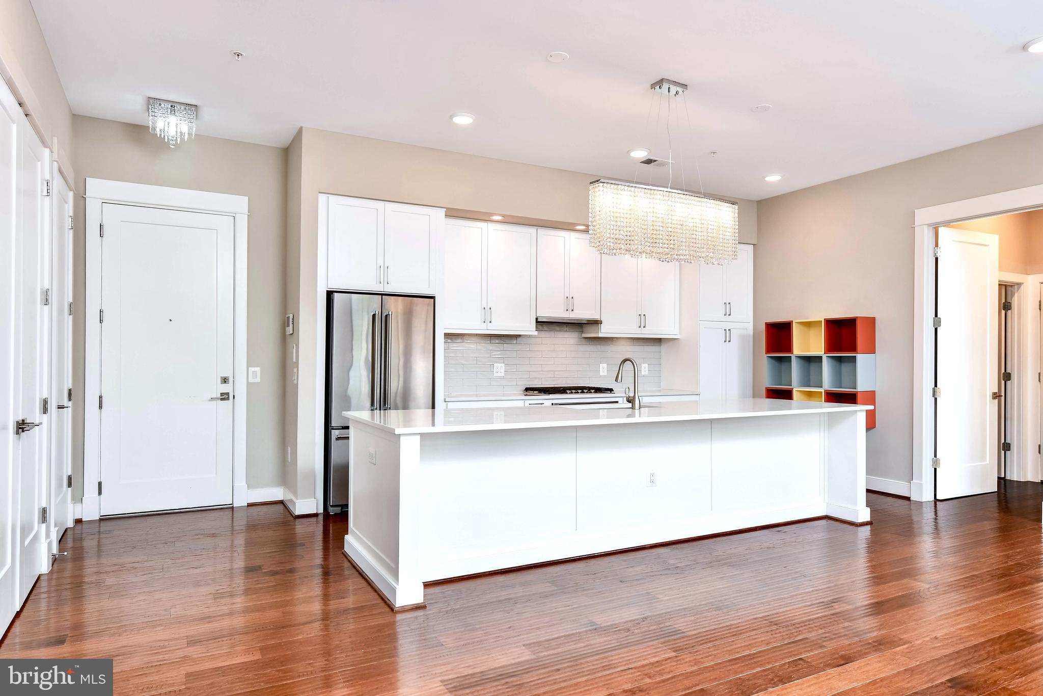 2 Stationmaster Street Southeast, Unit 302 Leesburg, VA 20175 - Photo 15 of 57 a large kitchen with stainless steel appliances a refrigerator and a stove top oven