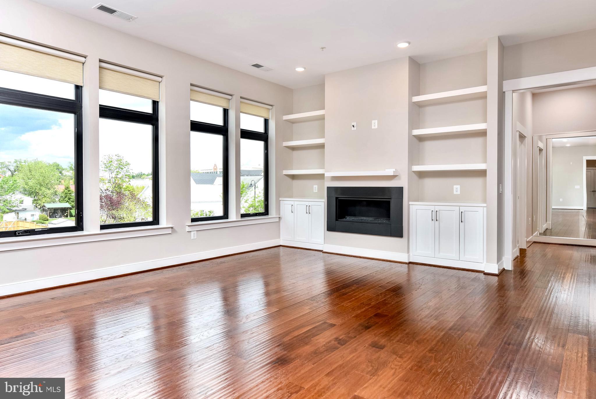 2 Stationmaster Street Southeast, Unit 302 Leesburg, VA 20175 - Photo 17 of 57 an empty room with wooden floor and windows