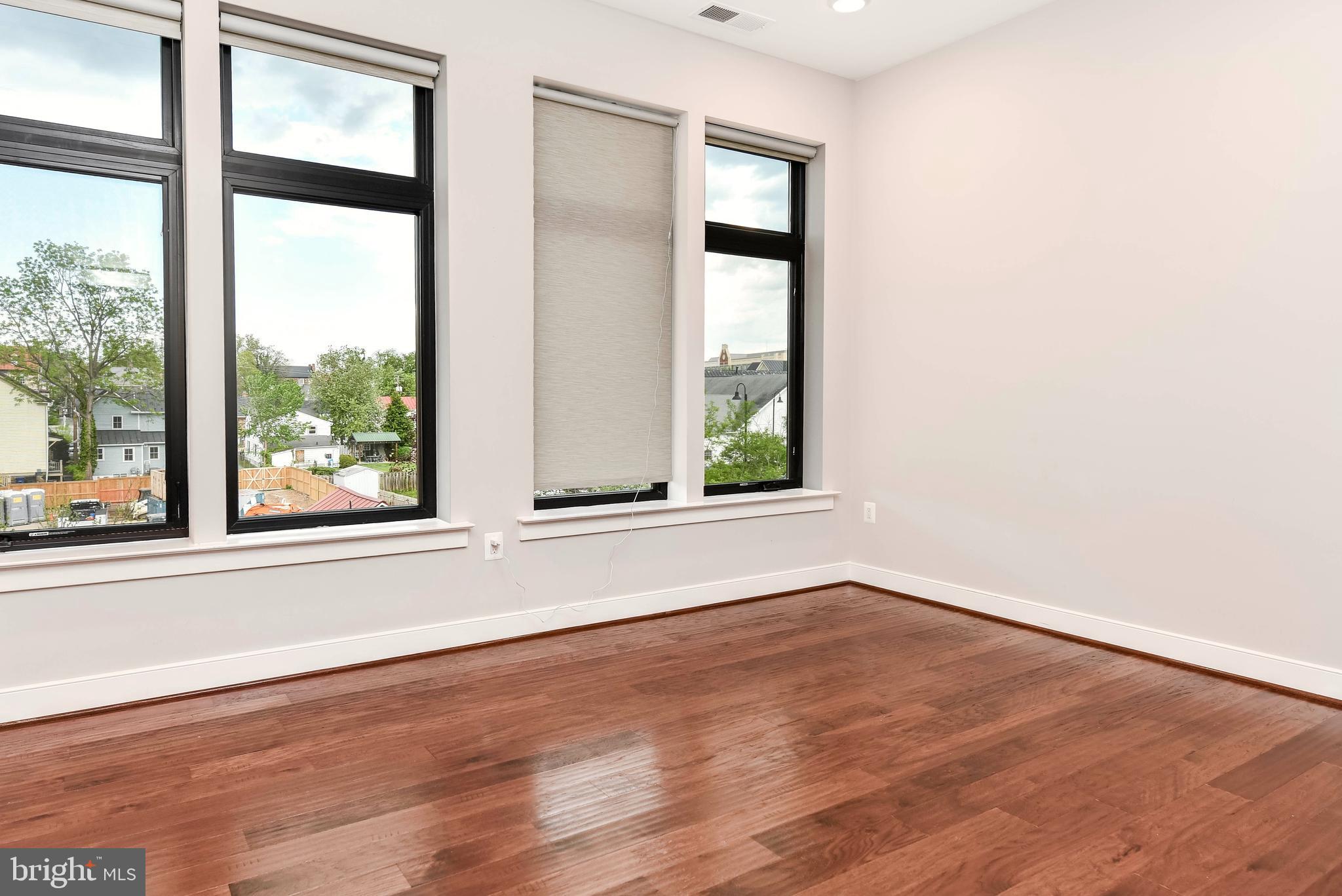 2 Stationmaster Street Southeast, Unit 302 Leesburg, VA 20175 - Photo 27 of 57 an empty room with wooden floor and windows