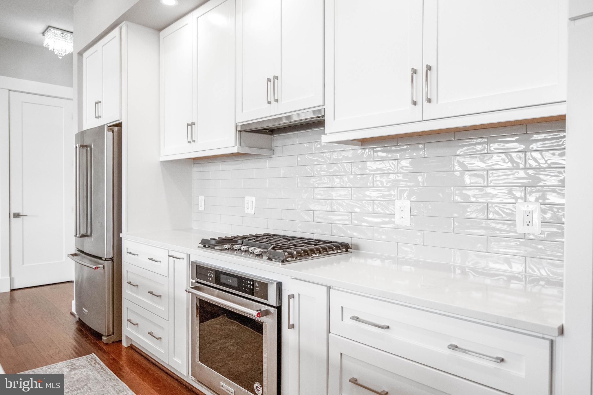 2 Stationmaster Street Southeast, Unit 302 Leesburg, VA 20175 - Photo 9 of 57 a kitchen with stainless steel appliances white cabinets and a stove