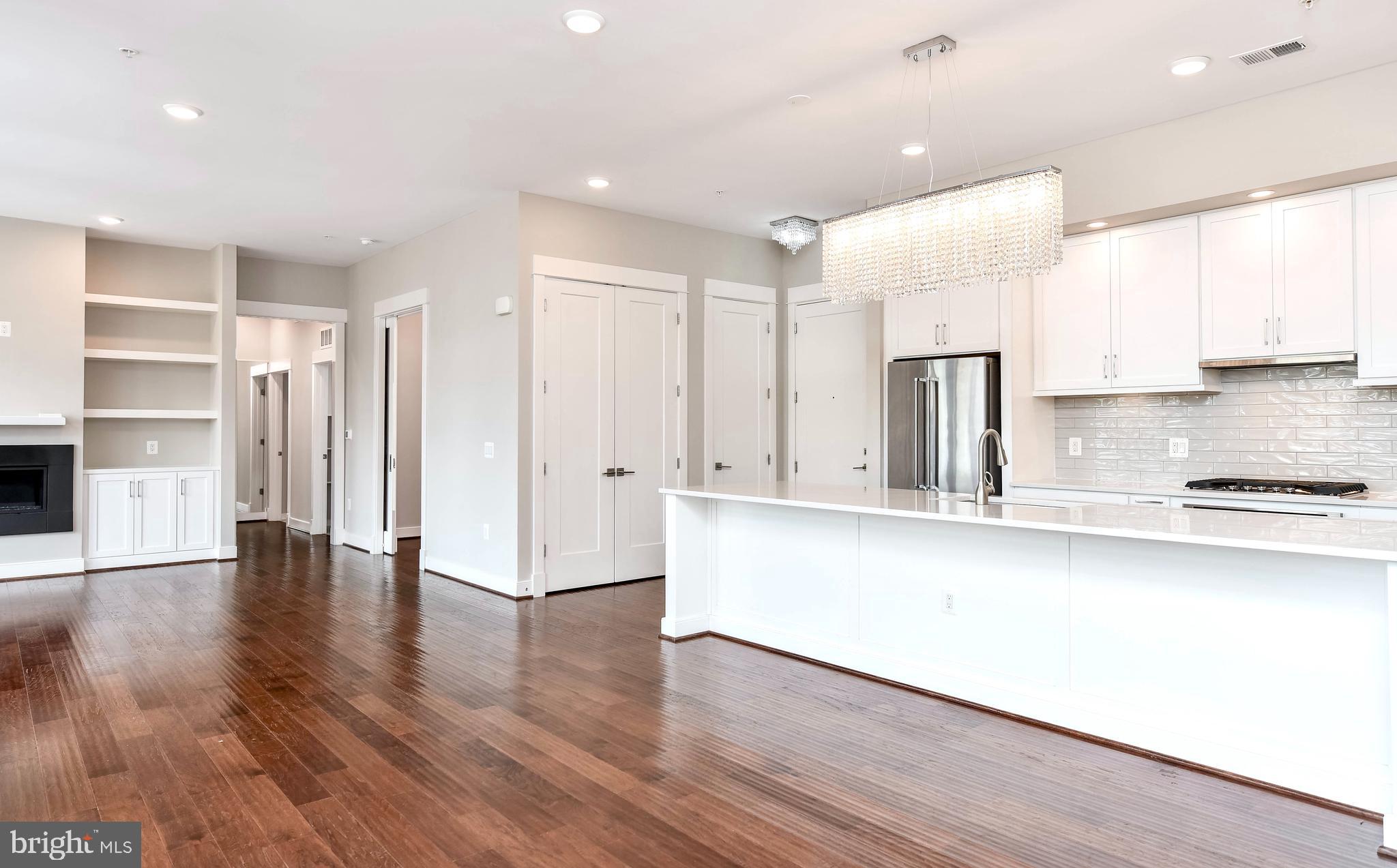 2 Stationmaster Street Southeast, Unit 302 Leesburg, VA 20175 - Photo 10 of 57 a large kitchen with stainless steel appliances granite countertop a refrigerator a sink and wooden floors