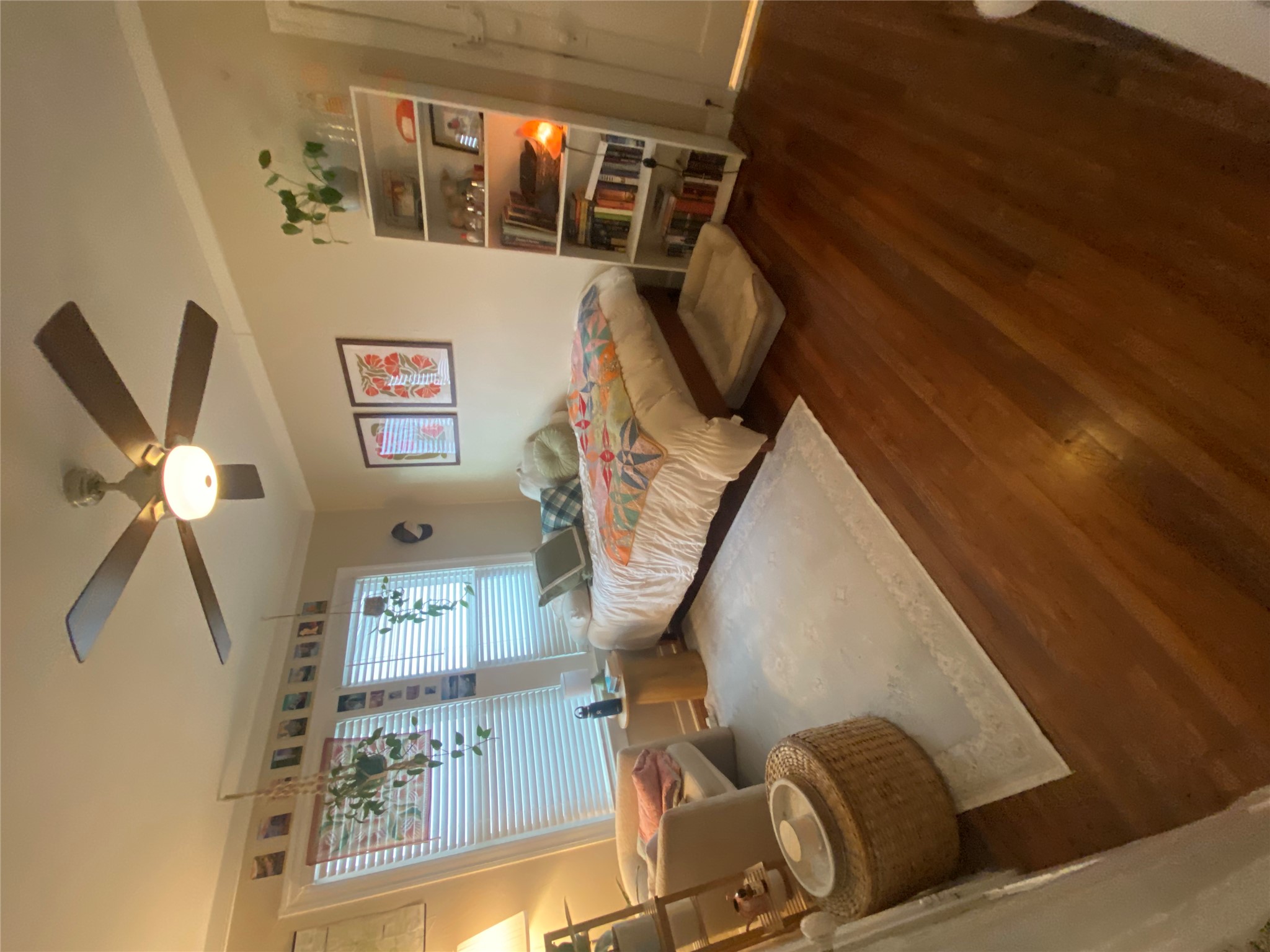 3010 Fruth Street, Unit A Austin, TX 78705 - Photo 24 of 39 Bedroom featuring warm wood-finish flooring, a ceiling fan with integrated lighting, and multiple windows with blinds