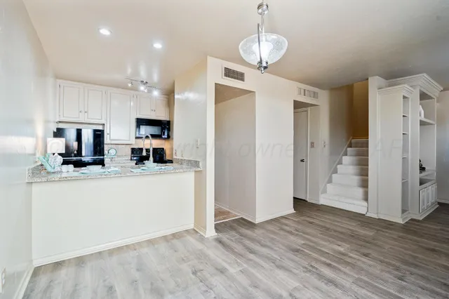 a kitchen with stainless steel appliances granite countertop a refrigerator and a stove top oven