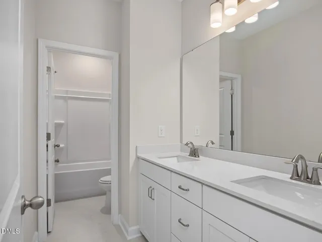 a bathroom with a granite countertop sink mirror and a bathtub