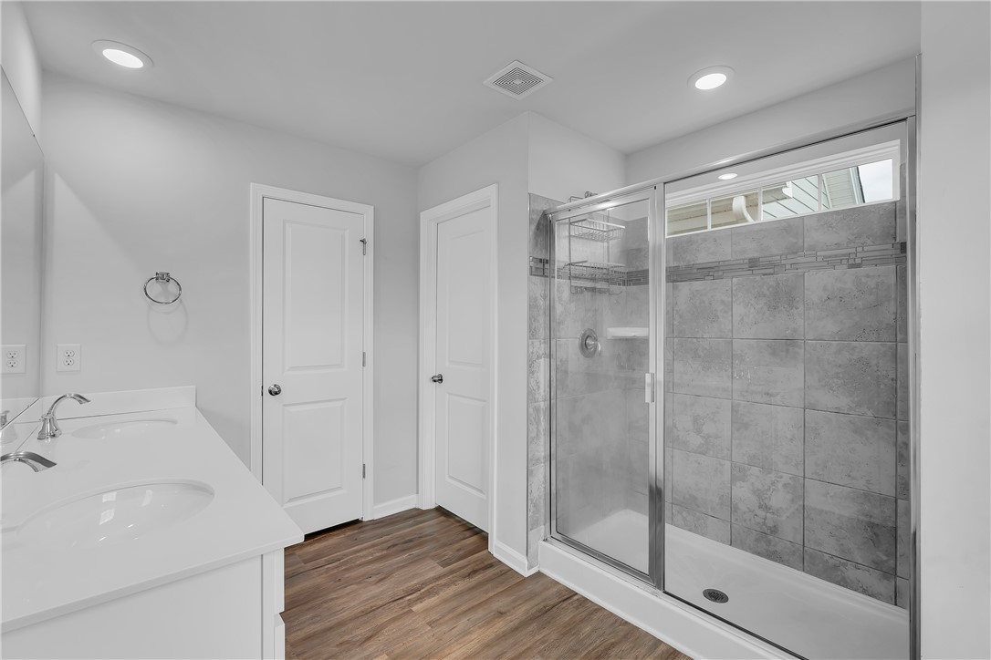 8 Leander Drive Greer, SC 29651 - Photo 24 of 31 A well-appointed bathroom offers dual vanities and a spacious walk-in shower.