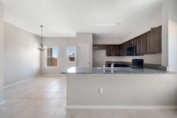 a large kitchen with kitchen island a sink a counter top space and cabinets