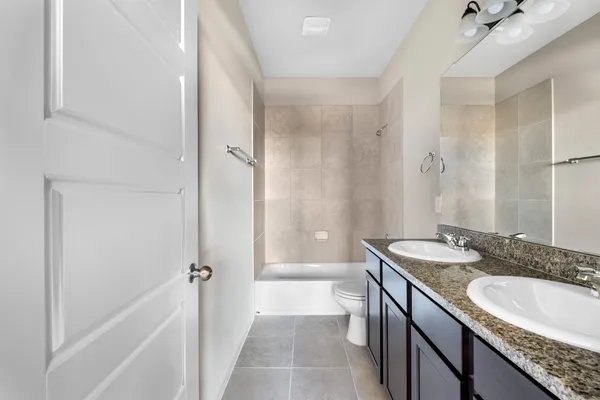 a bathroom with a granite countertop bathtub shower sink and mirror