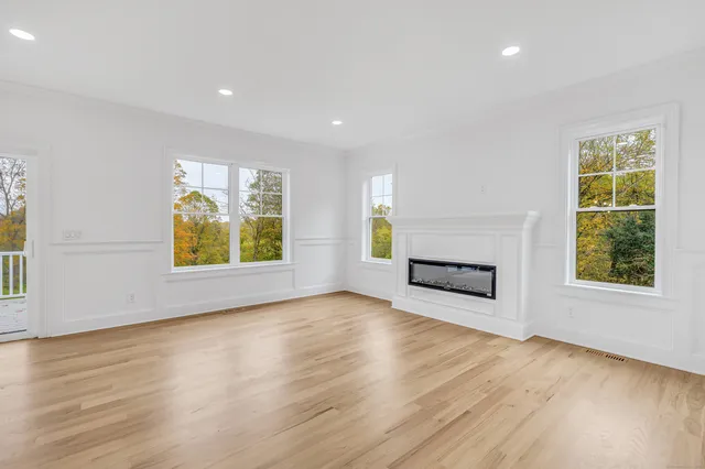 an empty room with windows and fireplace