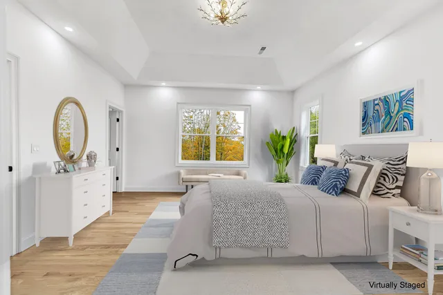 a bedroom with a large bed and a chandelier