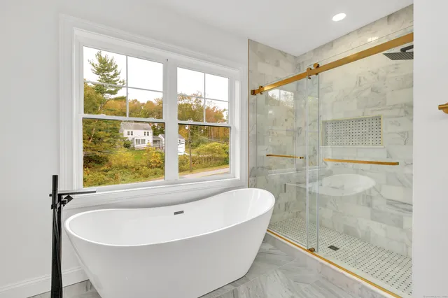 a white bath tub sitting next to a shower