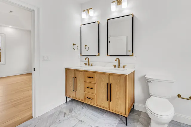 a bathroom with a granite countertop toilet sink and a mirror