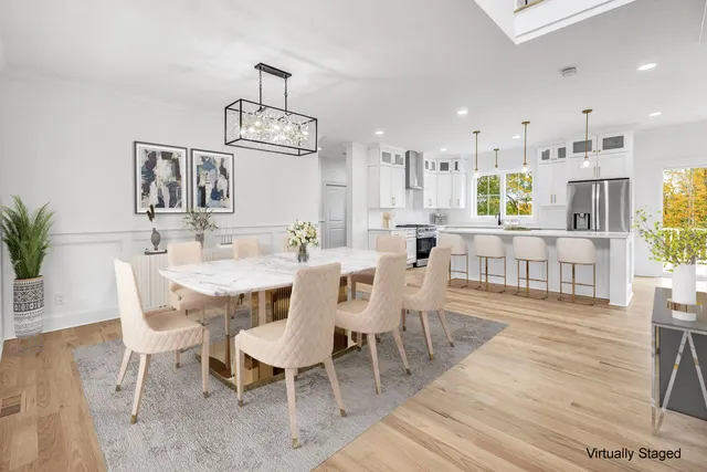 a dining room with wooden floor a chandelier a wooden table and chairs