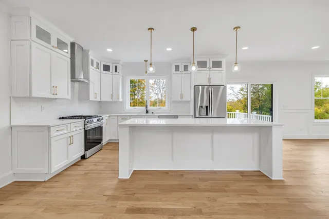 a kitchen with kitchen island granite countertop a stove a sink a center island and wooden floor