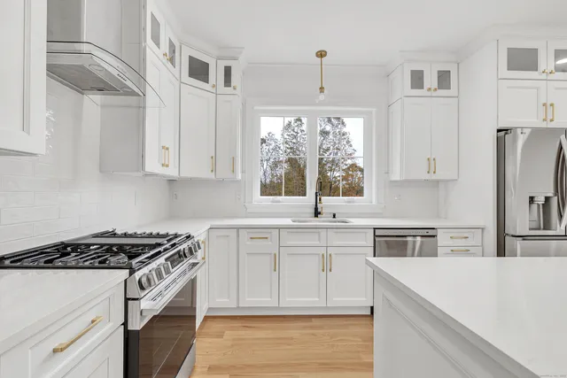 a kitchen with stainless steel appliances granite countertop a stove a sink dishwasher and a refrigerator